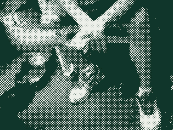 A clinic volunteer bandaging a patient's hand.